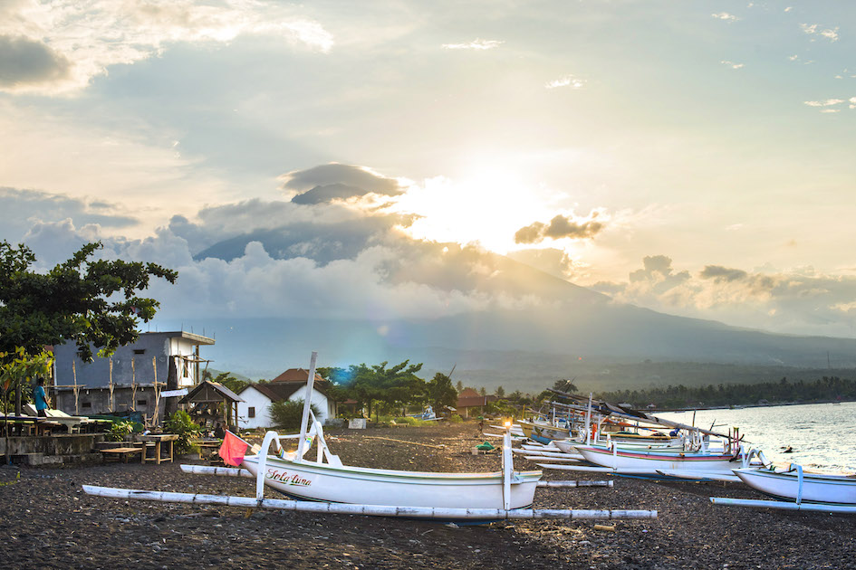 The last rays of sun on the sleepy beach of Amed before it sets behind Mt. Agung, Bali