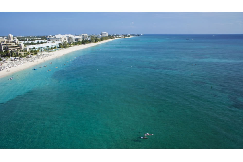 Stand up paddlers enjoy 7-Mile Beach, seen from the Air Vu Drone.