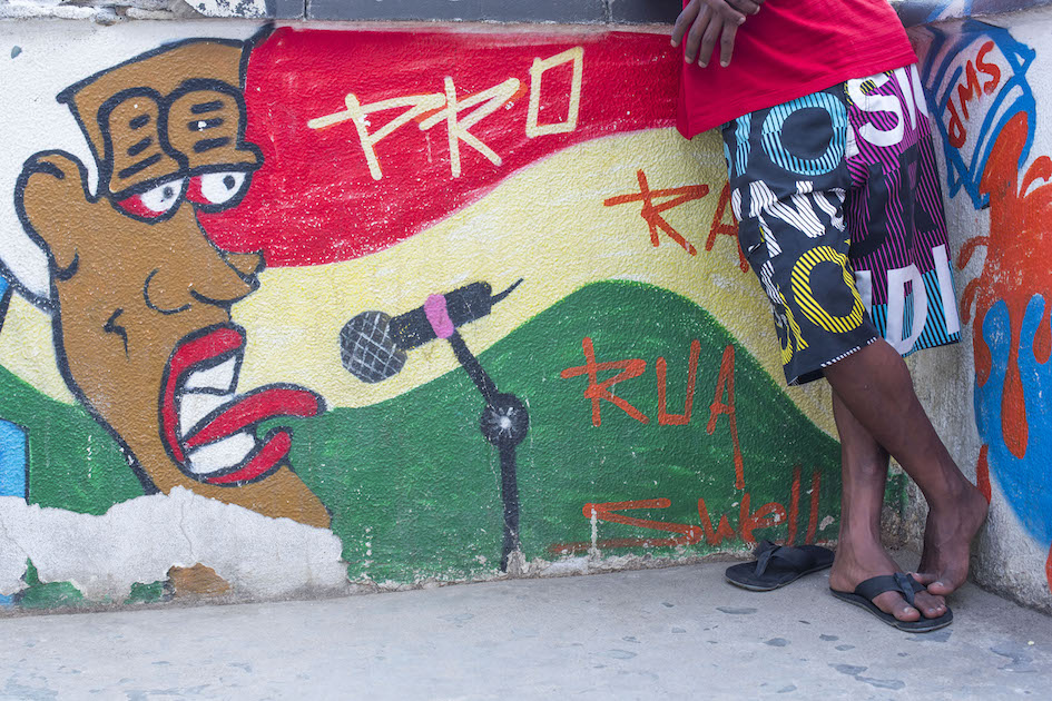 Man in shorts, graffiti on wall. Santa Marta Favela, Rio de Janerio.