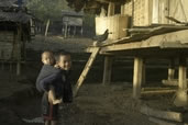 Young boy babysitting his even younger brother, Ahka village