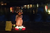 Lantern sales girl sitting along the Thu Bon River, Hoi An